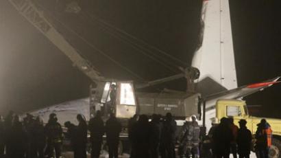 A worker operates a crane near the damaged Antonov 24 turboprop plane near the airport in Donetsk, February 13, 2013.(Reuters / Stringer)