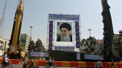 A huge picture of Iranian supreme leader Ayatollah Ali Khamenei is erected between a Sajjil (R) and Qadr-F (L) missiles (AFP Photo / ATTA KENARE)