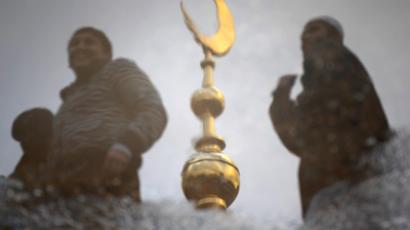 Muslim men and a crescent moon reflected in a puddle during the Eid al-Adha (Kurban Bairam in Russian) festival of sacrifice holiday in Moscow. (AFP Photo / Dmitry Kostyukov)
