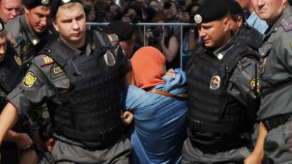 Moscow : Russian riot policemen detain a supporter of all-girl punk band "Pussy Riot" near a court building in Moscow on Agust 17, 2012.