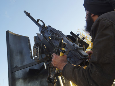 A Free Syrian Army fighter aims his weapon towards a Syrian military warplane (not pictured) in Aleppo's al-Amereya district December 12, 2012. (Reuters/Saleh Anadani)