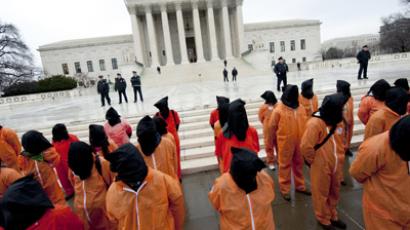 Protesters wearing orange prison jump suits and black hoods on their heads march during a protest against holding detainees at the military prison in Guantanamo Bay during a demonstration in front of the US Supreme Court in Washington (AFP Photo)
