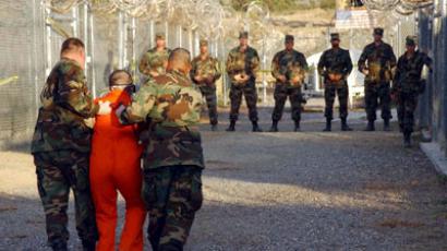 U.S. Army Military Police escort a detainee to his cell during in-processing to the temporary detention facility at Camp X-Ray in Naval Base Guantanamo Bay.(Reuters / Stringer)