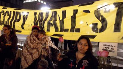 People affiliated with the Occupy Wall Street movement stand beneath a banner after being ordered to stop camping in Union Square in New York March 21, 2012. (Reuters / Andrew Kelly)