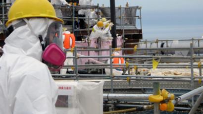 Workers removing fresh nuclear fuel (black pole at centre), for the first time since last year's tsunami-sparked crisis, from the spent fuel pool of the Unit 4 nuclear reactor building at TEPCO's Fukushima Dai-ichi nuclear power plant at Okuma town in Fukushima prefecture (AFP Photo / Tepco)