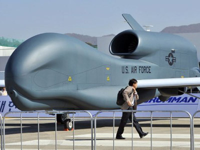 A man walks past a US Air Force Global Hawk unmanned aerial vehicle hanger during a preview day of the Seoul International Aerospace and Defense Exhibition at a military air base in Seongnam, south of Seoul, on October 17, 2011. (AFP Photo / JungYeon-Je)