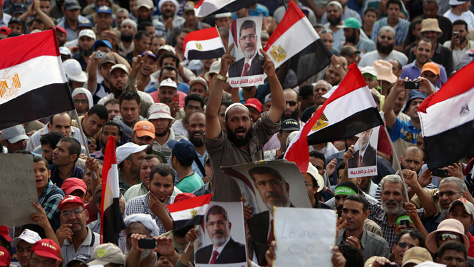 Supporters of deposed Egyptian president Mohamed Morsi hold portraits of him and national flags during a rally on July 9, 2013 outside Cairo's Rabaa al-Adawiya mosque (AFP Photo/Mahmud Hams)