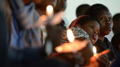 Rwandan women hold candles during a night vigil and prayer for genocide victims at the Amahoro stadium in Kigali, Rwanda, on April 7, 2014. (AFP Photo / Simon Maina)