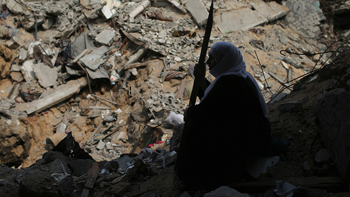 A Palestinian woman sits next to her destroyed house after returning to it in the Shejaia neighborhood, which witnesses said was heavily hit by Israeli shelling and air strikes during an Israeli offensive, in the east of Gaza City August 5, 2014 (Reuters / Mohammed Salem)