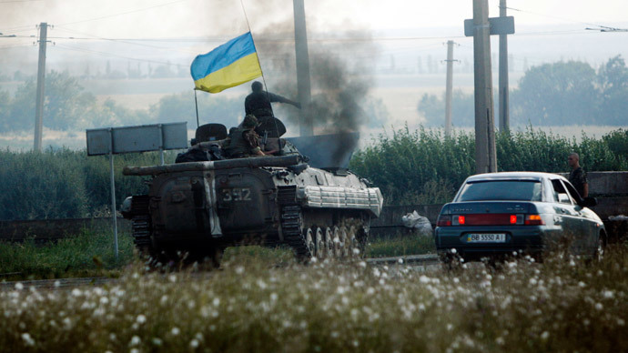 Ukrainian servicemen drive a military armoured vehicle along a road in Donetsk region August 6, 2014.(Reuters / Valentyn Ogirenko)