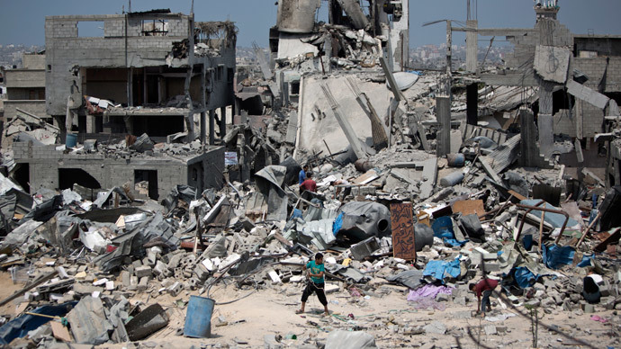 Palestinian men walk on the rubble of their destroyed houses in the Tufah neighbourhood in eastern Gaza City on August 31, 2014.(AFP Photo / Mahmud Hams )